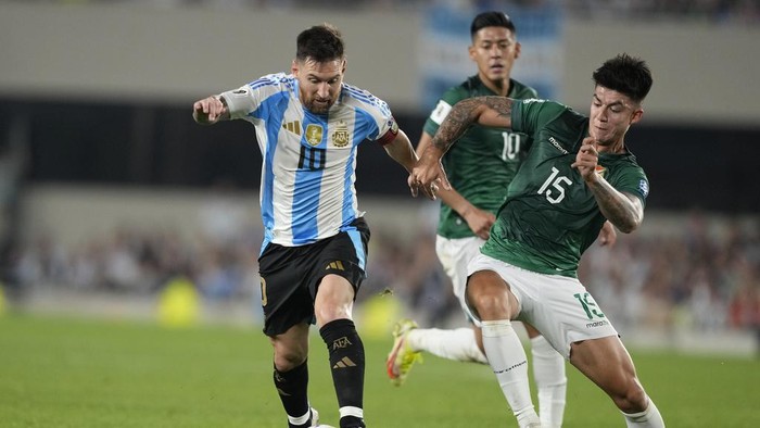 Argentinas Lionel Messi, left, is challenged by Bolivias Gabriel Villamil during a World Cup 2026 qualifying soccer match at Monumental stadium in Buenos Aires, Argentina, Tuesday, Oct. 15, 2024. (AP Photo/Natacha Pisarenko)