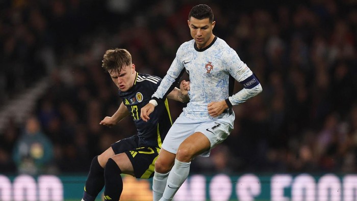 Soccer Football - UEFA Nations League - Group A1 - Scotland v Portugal - Hampden Park, Glasgow, Scotland, Britain - October 15, 2024 Portugals Cristiano Ronaldo in action with Scotlands Ben Doak Action Images via Reuters/Lee Smith