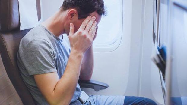 headache in the airplane, man passenger afraid and feeling bad during the flight in plane