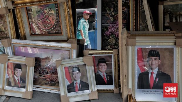 Perajin memasang pigura foto Presiden dan Wakil Presiden terpilih Prabowo Subianto dan Gibran Rakabuming Raka di Pasar Baru, Jakarta, Sabtu, 19 Oktober 2024. (CNNIndonesia/Adhi Wicaksono)