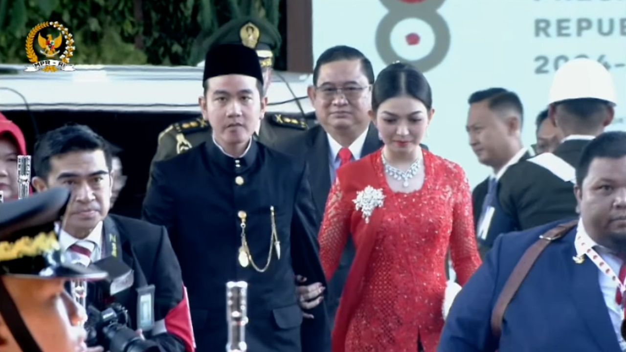Cawapres terpilih, Gibran Rakabuming Raka, tiba di gedung DPR/MPMR jelang pelantikan. Tampak Gibran mengenakan baeskap Betawi dan Selvi Ananda mengenakan kebaya merah.