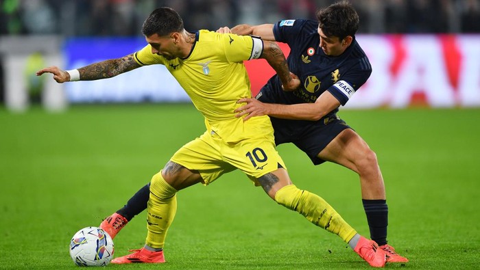 TURIN, ITALY - OCTOBER 19: Mattia Zaccagni of Lazio is challenged by Andrea Cambiaso of Juventus during the Serie A match between Juventus and SS Lazio at  on October 19, 2024 in Turin, Italy. (Photo by Valerio Pennicino/Getty Images)