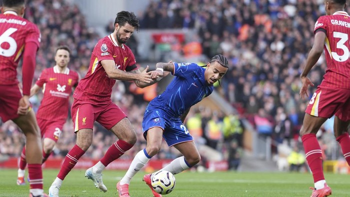 Chelseas Malo Gusto, centre right, challenges for the ball with Liverpools Dominik Szoboszlai during the English Premier League soccer match between Liverpool and Chelsea at Anfield Stadium, Liverpool, England, Sunday, Oct. 20, 2024. (AP Photo/Jon Super)