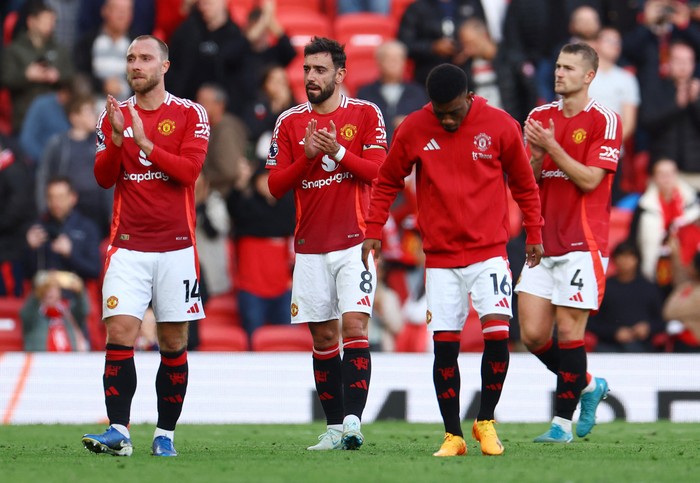 Soccer Football - Premier League - Manchester United v Brentford - Old Trafford, Manchester, Britain - October 19, 2024 Manchester Uniteds Christian Eriksen, Manchester Uniteds Bruno Fernandes and Manchester Uniteds Matthijs de Ligt applaud fans after the match REUTERS/Molly Darlington EDITORIAL USE ONLY. NO USE WITH UNAUTHORIZED AUDIO, VIDEO, DATA, FIXTURE LISTS, CLUB/LEAGUE LOGOS OR LIVE SERVICES. ONLINE IN-MATCH USE LIMITED TO 120 IMAGES, NO VIDEO EMULATION. NO USE IN BETTING, GAMES OR SINGLE CLUB/LEAGUE/PLAYER PUBLICATIONS. PLEASE CONTACT YOUR ACCOUNT REPRESENTATIVE FOR FURTHER DETAILS..