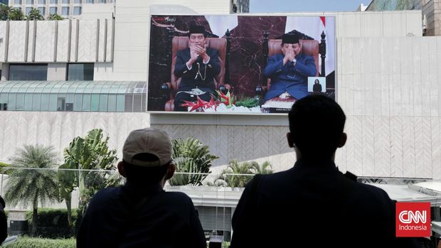 Warga menyaksikan pelantikan memadati  Presiden dan Wakil Presiden baru Indonesia Prabowo Subianto dan Gibran Rakabumin di  kawasan Jalan Sudirman di Jakarta, Minggu (20/10/2024). (CNN Indonesia/Safir Makki)