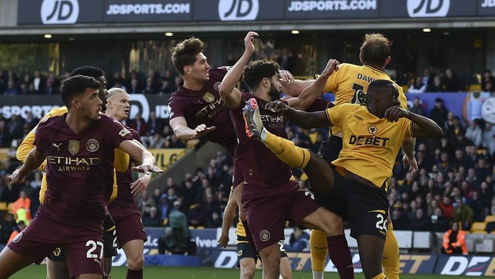 Manchester Citys John Stones, top left, scores his sides 2nd goal during the English Premier League soccer match between Wolverhampton Wanderers and Manchester City at the Molineux Stadium in Wolverhampton, England, Sunday, Oct. 20, 2024. (AP Photo/Rui Vieira)