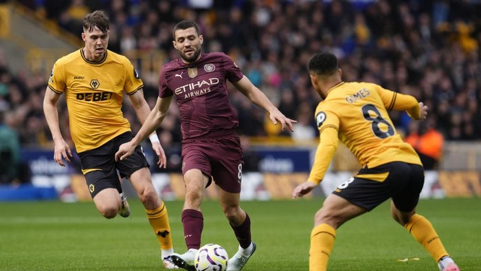 Manchester Citys Mateo Kovacic (centre) and Wolverhampton Wanderers Joao Gomes (right) battle for the ball during the Premier League match at Molineux Stadium, Wolverhampton. Picture date: Sunday October 20, 2024. (Photo by Nick Potts/PA Images via Getty Images)