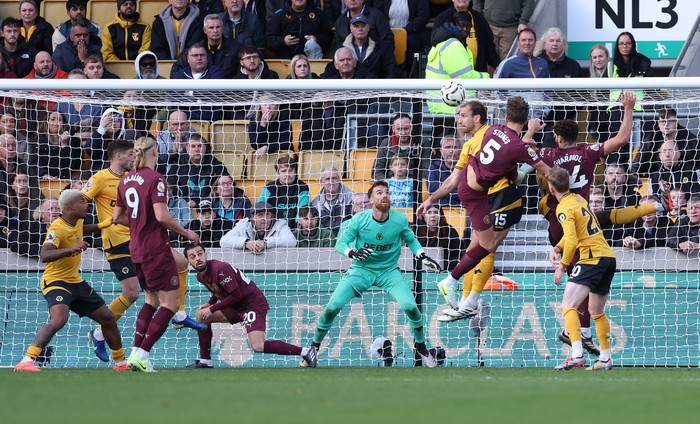 WOLVERHAMPTON, ENGLAND - OCTOBER 20: John Stones of Manchester City beats Jose Sa of Wolverhampton Wanderers with a header to score the winning goal in stoppage time as Bernardo Silva ducks out of the way during the Premier League match between Wolverhampton Wanderers FC and Manchester City FC at Molineux on October 20, 2024 in Wolverhampton, England. (Photo by Alex Livesey - Danehouse/Getty Images)