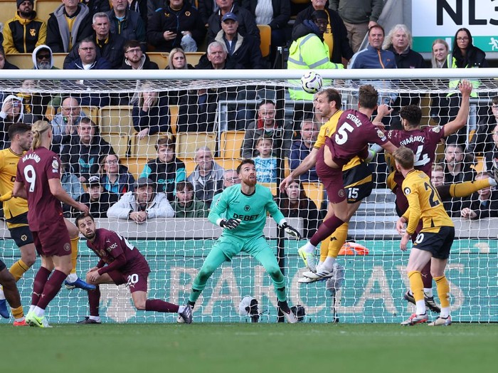 WOLVERHAMPTON, ENGLAND - OCTOBER 20: John Stones of Manchester City beats Jose Sa of Wolverhampton Wanderers with a header to score the winning goal in stoppage time as Bernardo Silva ducks out of the way during the Premier League match between Wolverhampton Wanderers FC and Manchester City FC at Molineux on October 20, 2024 in Wolverhampton, England. (Photo by Alex Livesey - Danehouse/Getty Images)