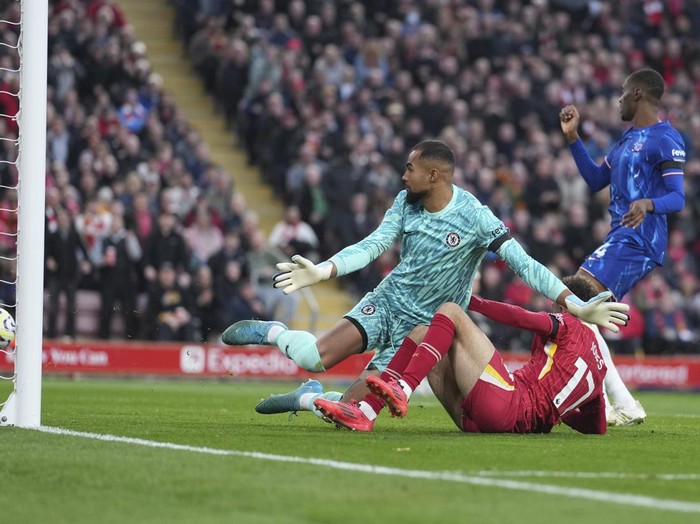 Liverpool's Curtis Jones, right, scores his side's second goal past Chelsea's goalkeeper Robert Sanchez during the English Premier League soccer match between Liverpool and Chelsea at Anfield Stadium, Liverpool, England, Sunday, Oct. 20, 2024. (AP Photo/Jon Super)