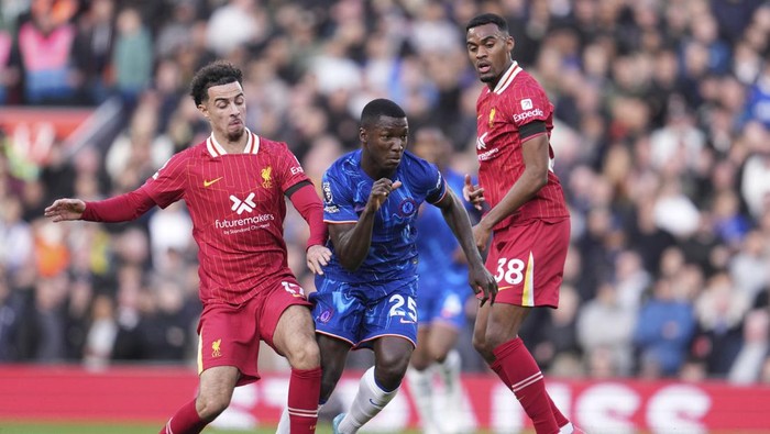 Chelseas Moises Caicedo, centre, challenges for the ball with Liverpools Curtis Jones, left, and Liverpools Ryan Gravenberch during the English Premier League soccer match between Liverpool and Chelsea at Anfield Stadium, Liverpool, England, Sunday, Oct. 20, 2024. (AP Photo/Jon Super)