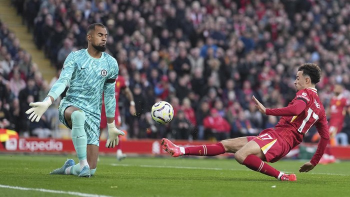 Liverpools Curtis Jones, right, scores his sides second goal past Chelseas goalkeeper Robert Sanchez during the English Premier League soccer match between Liverpool and Chelsea at Anfield Stadium, Liverpool, England, Sunday, Oct. 20, 2024. (AP Photo/Jon Super)