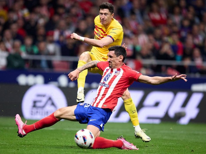 MADRID, SPAIN - MARCH 17: Robert Lewandowski of FC Barcelona competes for the ball with Stefan Savic of Atletico de Madrid during the LaLiga EA Sports match between Atletico Madrid and FC Barcelona at Civitas Metropolitano Stadium on March 17, 2024 in Madrid, Spain. (Photo by Alvaro Medranda/Quality Sport Images/Getty Images)
