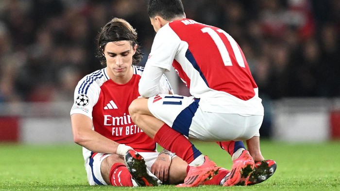 LONDON, ENGLAND - OCTOBER 22: Riccardo Calafiori of Arsenal goes down with a injury as Gabriel Martinelli of Arsenal checks on him during the UEFA Champions League 2024/25 League Phase MD3 match between Arsenal FC and FC Shakhtar Donetsk at Emirates Stadium on October 22, 2024 in London, England. (Photo by David Price/Arsenal FC via Getty Images)
