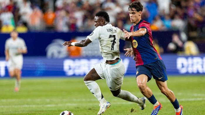 EAST RUTHERFORD, NEW JERSEY - AUGUST 3: Vinícius Junior #7 of Real Madrid fights to keep control of the ball against Marc Bernal #16 of FC Barcelona  in the second half of the pre-season friendly match at MetLife Stadium on August 3, 2024 in East Rutherford, New Jersey. (Photo by Ira L. Black - Corbis/Getty Images)