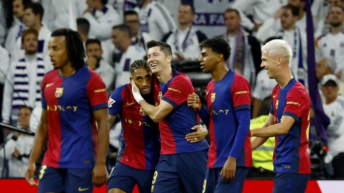 Soccer Football - LaLiga - Real Madrid v FC Barcelona - Santiago Bernabeu, Madrid, Spain - October 26, 2024 FC Barcelonas Raphinha celebrates scoring their fourth goal with Robert Lewandowski and teammates REUTERS/Susana Vera