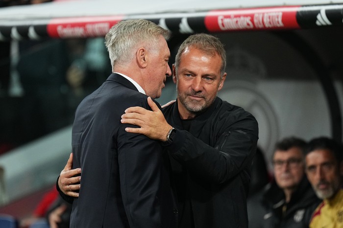 MADRID, SPAIN - OCTOBER 26: Hansi Flick, Head Coach of FC Barcelona, interacts with Carlo Ancelotti, Head Coach of Real Madrid, prior to the LaLiga match between Real Madrid CF and FC Barcelona at Estadio Santiago Bernabeu on October 26, 2024 in Madrid, Spain. (Photo by Angel Martinez/Getty Images)