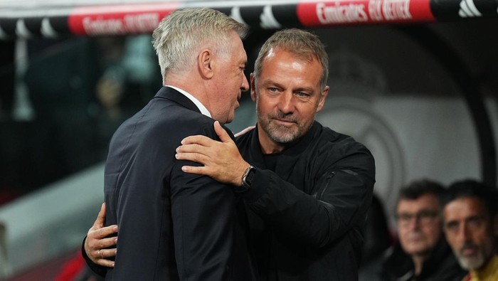 MADRID, SPAIN - OCTOBER 26: Hansi Flick, Head Coach of FC Barcelona, interacts with Carlo Ancelotti, Head Coach of Real Madrid, prior to the LaLiga match between Real Madrid CF and FC Barcelona at Estadio Santiago Bernabeu on October 26, 2024 in Madrid, Spain. (Photo by Angel Martinez/Getty Images)