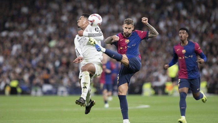 Jude Bellingham of Real Madrid and Inigo Martinez of Barcelona fight for the ball during the La Liga 2024/25 match between Real Madrid and F.C. Barcelona at Santiago Bernabeu Stadium in Madrid, Spain, on October 26. (Photo by Guillermo Martinez/NurPhoto via Getty Images)