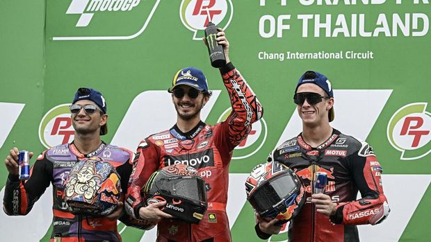 Ducati Lenovo Team's Italian rider Francesco Bagnaia (C) celebrates on the podium after winning the MotoGP Thailand Grand Prix with second place Prima Pramac Racing's Spanish rider Jorge Martin (L) and third place RedBull GASGAS Tech3's Spanish rider Pedro Acosta (R) at the Buriram International Circuit in Buriram on October 27, 2024. (Photo by Lillian SUWANRUMPHA / AFP)