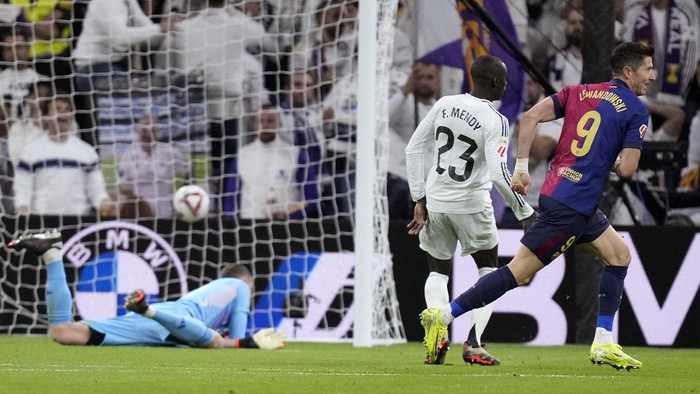 Barcelonas Robert Lewandowski scores his sides first goal during a Spanish La Liga soccer match between Real Madrid and Barcelona at the Santiago Bernabeu stadium in Madrid, Spain, Saturday, Oct. 26, 2024. (AP Photo/Bernat Armangue)