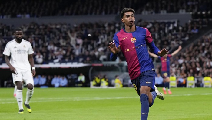 Barcelonas Lamine Yamal celebrates after scoring his sides third goal during a Spanish La Liga soccer match between Real Madrid and Barcelona at the Santiago Bernabeu stadium in Madrid, Spain, Saturday, Oct. 26, 2024. (AP Photo/Manu Fernandez)