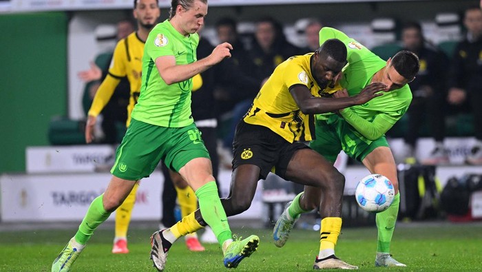 WOLFSBURG, GERMANY - OCTOBER 29: Serhou Guirassy of Borussia Dortmund battles for possession with Patrick Wimmer and Bence Dardai of VfL Wolfsburg during the DFB-Pokal match between VfL Wolfsburg and Borussia Dortmund at Volkswagen Arena on October 29, 2024 in Wolfsburg, Germany. (Photo by Stuart Franklin/Getty Images)