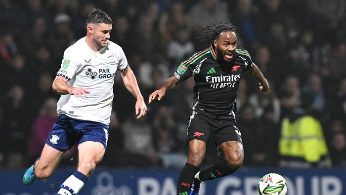 PRESTON, ENGLAND - OCTOBER 30: Raheem Sterling of Arsenal controls the ball under pressure from Andrew Hughes of Preston North End during the Carabao Cup Fourth Round match between Preston North End and Arsenal  at Deepdale on October 30, 2024 in Preston, England. (Photo by Stuart MacFarlane/Arsenal FC via Getty Images)