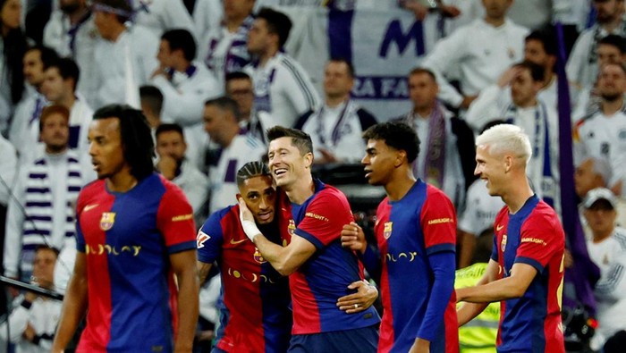 FILE PHOTO: Soccer Football - LaLiga - Real Madrid v FC Barcelona - Santiago Bernabeu, Madrid, Spain - October 26, 2024 FC Barcelonas Raphinha celebrates scoring their fourth goal with Robert Lewandowski and teammates REUTERS/Susana Vera/File Photo