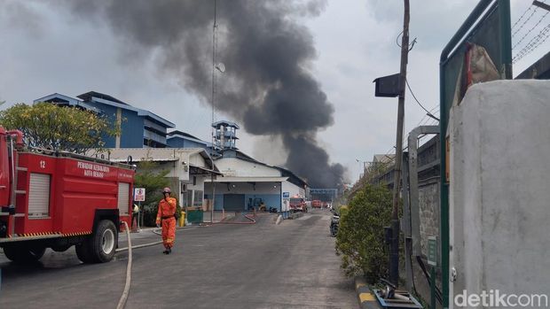 Kebakaran pabrik di Medan Satria, Kota Bekasi, belum padam. Seorang petugas pemadam kebakaran (damkar) yang mengalami sesak nafas dibawa ke RS. (MI Fawdi/detikcom)