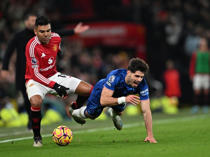 MANCHESTER, ENGLAND - NOVEMBER 03: Pedro Neto of Chelsea is challenged by Casemiro of Manchester United during the Premier League match between Manchester United FC and Chelsea FC at Old Trafford on November 03, 2024 in Manchester, England. (Photo by Darren Walsh/Chelsea FC via Getty Images)