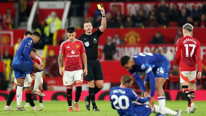 MANCHESTER, ENGLAND - NOVEMBER 03: Lisandro Martinez of Manchester United is shown a yellow card from referee Robert Jones after a foul on Cole Palmer of Chelsea during the Premier League match between Manchester United FC and Chelsea FC at Old Trafford on November 03, 2024 in Manchester, England. (Photo by Carl Recine/Getty Images)
