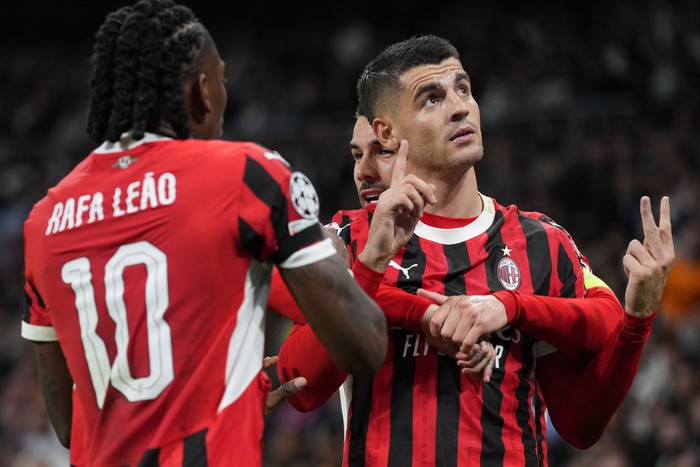 AC Milans Alvaro Morata, right, celebrates after scoring his sides 2nd goal against Real Madrid during the Champions League opening phase soccer match at the Santiago Bernabeu stadium in Madrid, Spain, Tuesday, Nov. 5, 2024. (AP Photo/Manu Fernandez)