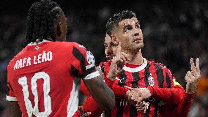 AC Milans Alvaro Morata, right, celebrates after scoring his sides 2nd goal against Real Madrid during the Champions League opening phase soccer match at the Santiago Bernabeu stadium in Madrid, Spain, Tuesday, Nov. 5, 2024. (AP Photo/Manu Fernandez)