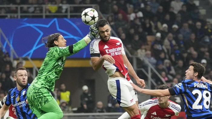Inter Milans goalkeeper Yann Sommer, top left, makes a safe on Arsenals Mikel Merino during a Champions League opening phase soccer match between Inter Milan and Arsenal at the San Siro stadium in Milan, Italy, Wednesday, Nov. 6, 2024. (AP Photo/Luca Bruno)