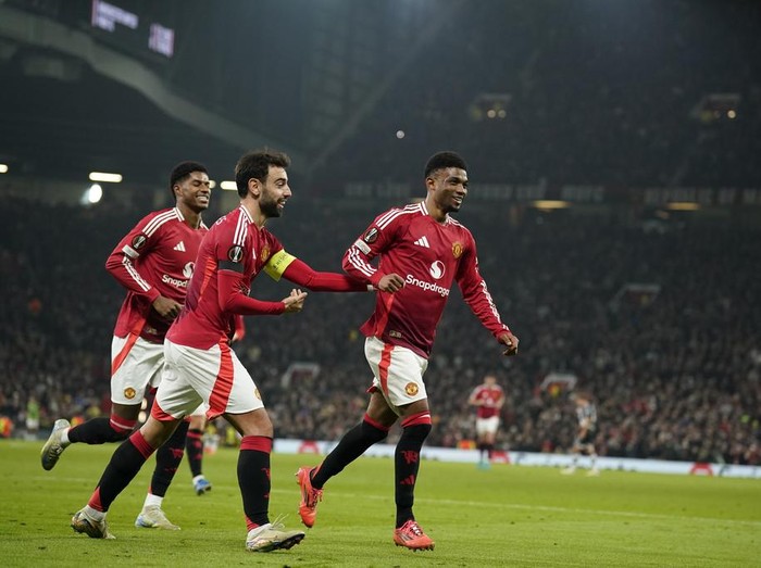 Manchester United's Amad Diallo, right, celebrates with teammates after scoring his side's second goal during the Europa League opening phase soccer match between Manchester United and PAOK at the Old Trafford stadium in Manchester, England, Thursday, Nov. 7, 2024. (AP Photo/Dave Thompson)