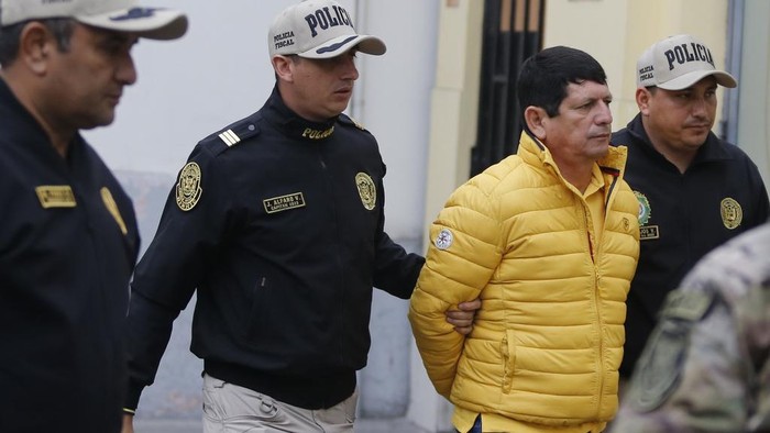 Police escort Agustin Lozano, head of Peru's soccer federation, after arresting him as part of an investigation into fraud, extortion and money laundering in Lima, Peru, Thursday, Nov. 7, 2024. (AP Photo/Jose Tejada)