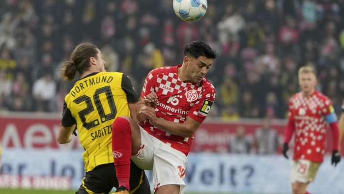 Dortmunds Marcel Sabitzer, left, and Mainzs Nadiem Amiri, right, challenge for the ball during the German Bundesliga soccer match between 1. FSV Mainz 05 and Borussia Dortmund in Mainz, Germany, Saturday, Nov. 9, 2024. (Thomas Frey/dpa via AP)