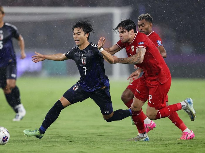 JAKARTA, INDONESIA - NOVEMBER 15: Kaoru Mitoma of Japan competes for the ball against Kevin Diks of Indonesia in the first half during the FIFA World Cup Asian 3rd Qualifier Group C match at Gelora Bung Karno Stadium on November 15, 2024 in Jakarta, Indonesia.  (Photo by Robertus Pudyanto/Getty Images)
