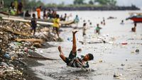 Anak-anak Berenang di Pantai Kalumata Ternate yang Tercemar Sampah