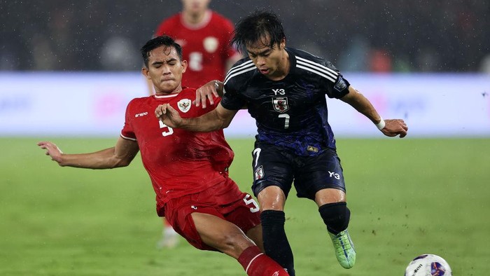 JAKARTA, INDONESIA - NOVEMBER 15: Kaoru Mitoma of Japan is tackled by Rizky Ridho Ramadhani of Indonesia in the first half during the FIFA World Cup Asian 3rd Qualifier Group C match at Gelora Bung Karno Stadium on November 15, 2024 in Jakarta, Indonesia.  (Photo by Robertus Pudyanto/Getty Images)