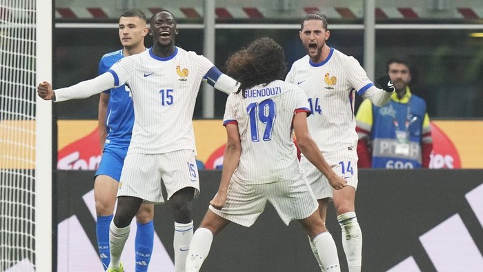 Frances Adrien Rabiot, right, celebrates with teammates after the Nations League soccer match between Italy and France, at the San Siro stadium in Milan, Italy, Sunday, Nov. 17, 2024. (AP Photo/Luca Bruno)