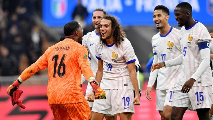 Soccer Football - Nations League - Group Stage - Italy v France - San Siro, Milan, Italy - November 17, 2024 Frances Mike Maignan and Frances Matteo Guendouzi celebrate after the match with teammates REUTERS/Jennifer Lorenzini