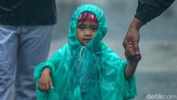 Suporter cilik pun ikut menerobos hujan deras di kawasan GBK, Jakarta.