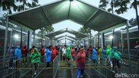 Meski kehujanan, para suporter tetap antre masuk stadion dengan tertib.