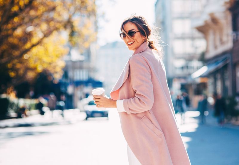 A young woman drinking coffee on her way to work.