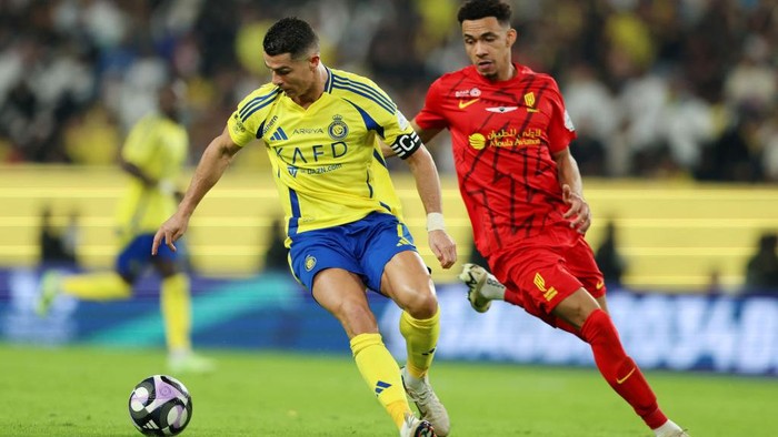 RIYADH, SAUDI ARABIA - NOVEMBER 22: Cristiano Ronaldo of Al Nassr runs with the ball whilst under pressure from Gaston Alvarez of Al-Qadisiyah during the Saudi Pro League match between Al-Nassr and Al-Qadsiah at Al Awwal Park on November 22, 2024 in Riyadh, Saudi Arabia. (Photo by Yasser Bakhsh/Getty Images)