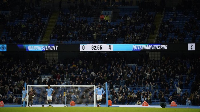 Manchester City players react after Tottenham scored their 4th goal, reflected on the scoreboard during the English Premier League soccer match between Manchester City and Tottenham at the Etihad Stadium in Manchester, England, Sunday, Nov. 24, 2024. (AP Photo/Dave Thompson)