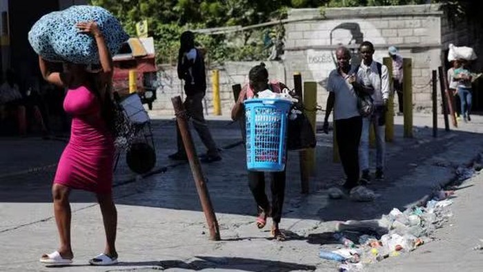 People carry their belongings while fleeing their neighborhood following gang attacks that sparked a violent civilian response, in Port-au-Prince, Haiti, November 19, 2024. RALPH TEDY EROL / REUTERS