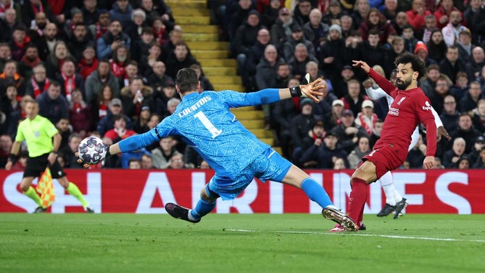 LIVERPOOL, ENGLAND - FEBRUARY 21: Mohamed Salah of Liverpool scores the teams second goal as Thibaut Courtois of Real Madrid attempts to make a save during the UEFA Champions League round of 16 leg one match between Liverpool FC and Real Madrid at Anfield on February 21, 2023 in Liverpool, England. (Photo by Alex Livesey - UEFA/UEFA via Getty Images)